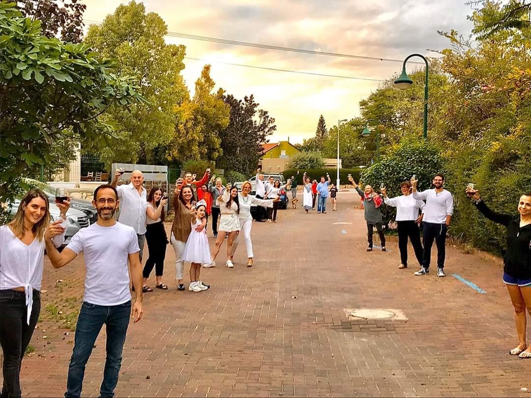 תושבי רחוב נרקיס בישוב מתן מרימים יחד כוס יין 