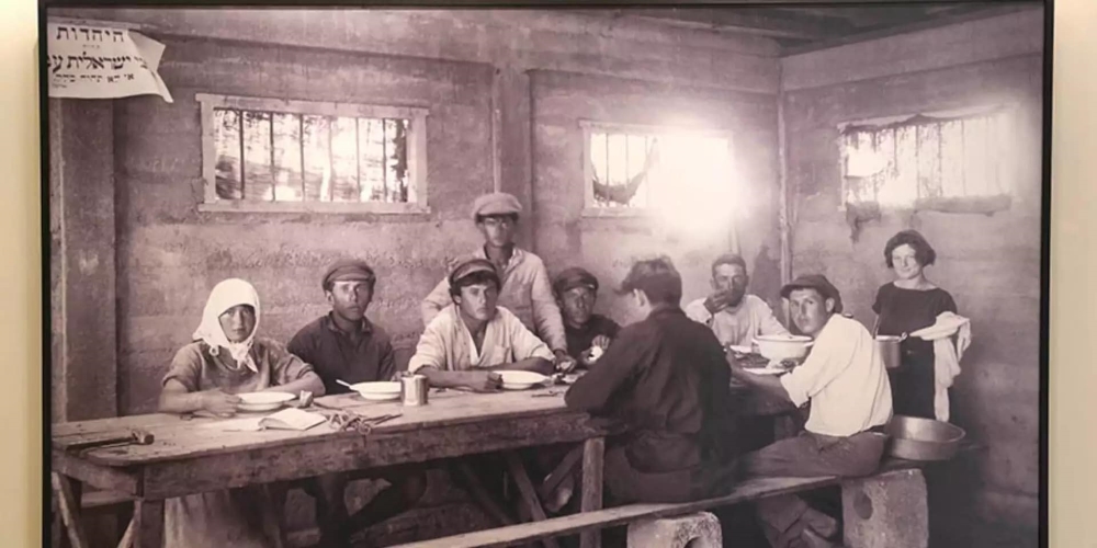 תמונת ארכיון של עובדים במושב נהלל יושבים לסעודה