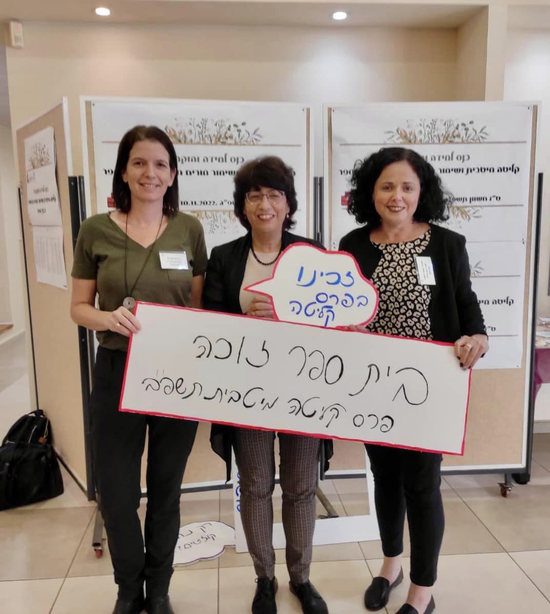 צוות הניהול של עמי אסף אוחזות בכרזה שכותרתה זכינו בפרס קליטה מיטבית לשנת תשפב