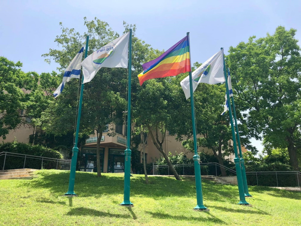 דגל מועצה אזורית דרום השרון לצד דגל ישראל ודגל הגאווה מונפים בחזית בניין המועצה