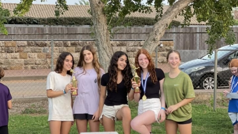 נערת משתתפות במרוץ צופית על הפודיום עם גביעי הזכייה.jpg